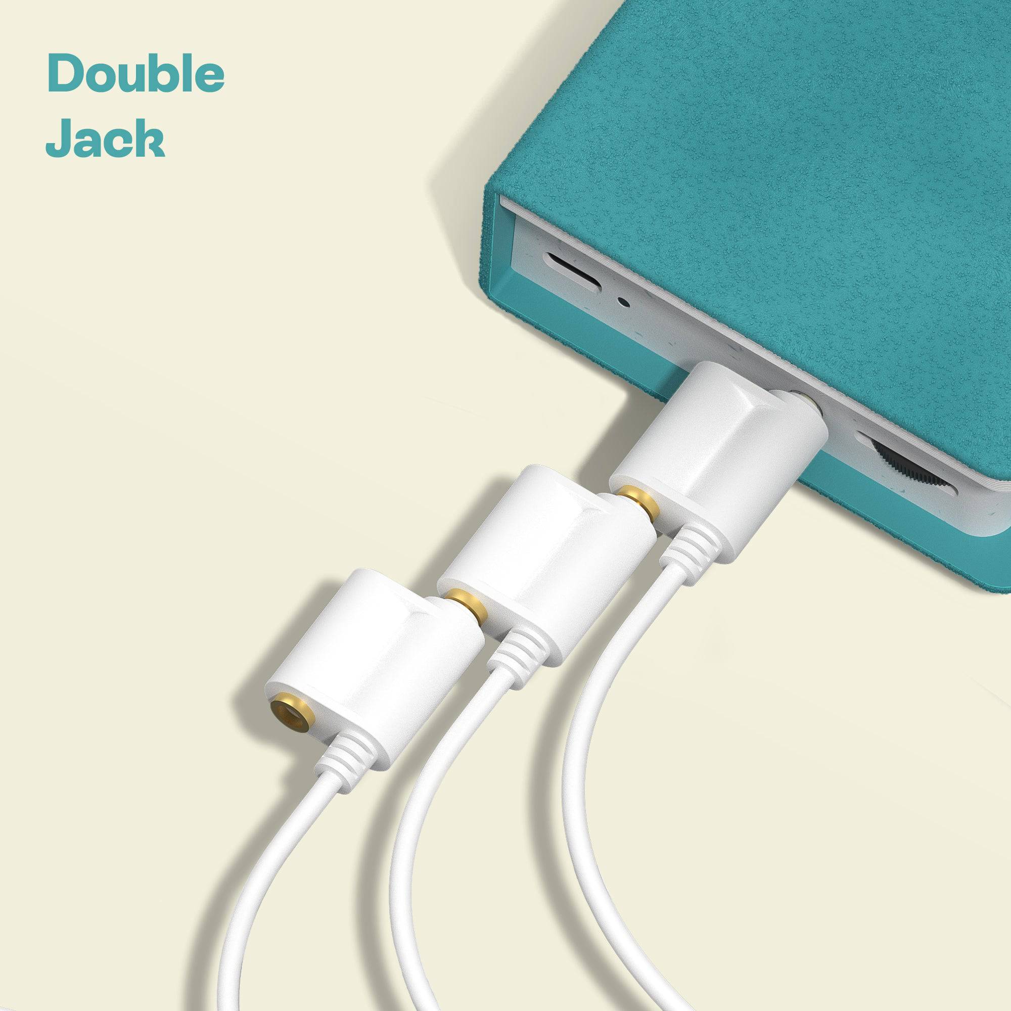 Close-up of a device with double headphone jack feature and three white audio cables connected